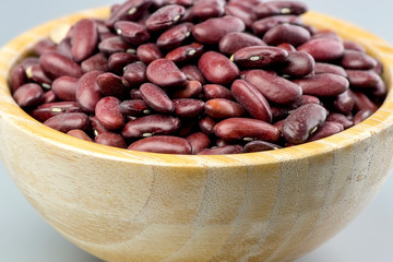 Closeup raw kidney beans in wooden bowl