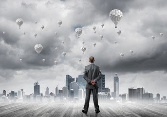 Motivation and inspiration concept with modern cityscape and businessman observing it