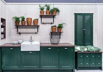 Spacious kitchen in Scandinavian style. Comfortable, functional furniture, simple forms and a large number of clay flower pots with cacti, paportnikami and succulents.