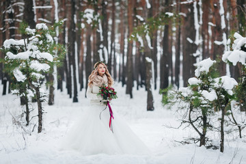Beautiful bride posing with bouquet in snowy forest. Winter wedding. Artwork. - 183107063
