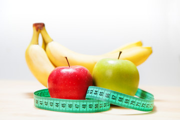 Healthy diet, fitness and weight loss concept, scales, measuring tape, fruits, vegetables on the table.