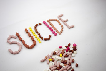 A suicide word, writing on the white background on pills