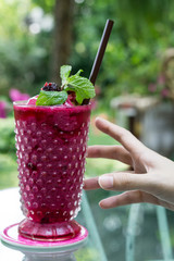 the glass of berry juice smoothie in garden