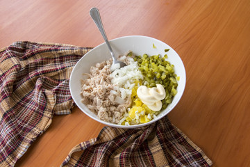 Sliced winter salad in a bowl on a wooden table covered with a towel