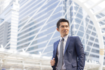 Young Hnadsome Businessman standing in City looking and ready for Work. Young Businessman have Confident for Work with Leader concept. Asian Businessman Thinking for Work in City.