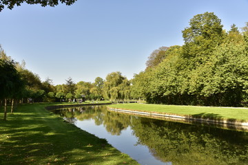 Courbe du chenal principal et son effet miroir reliant le petit et le grand étang  dans un cadre verdoyant au Vrijbroekpark à Malines