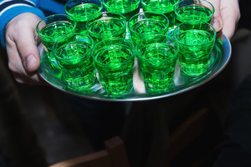 Green alcoholic beverages on a tray. Cocktail party. Horizontal format ..