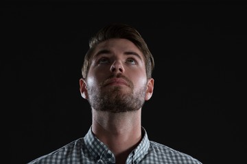 Man standing against black background