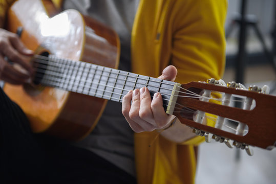 Close up of male arm playing guitar skillfully. Focus on man fingers touching the strings while doing accord