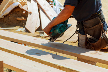 carpenter uses a circular saw to cut wood the work area