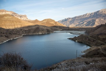 Горное озеро в живописном ущелье, панорама с красивыми скалами, водоем с голубой водой, природа Северного Кавказа