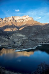 Горное озеро в живописном ущелье, панорама с красивыми скалами, водоем с голубой водой, природа Северного Кавказа