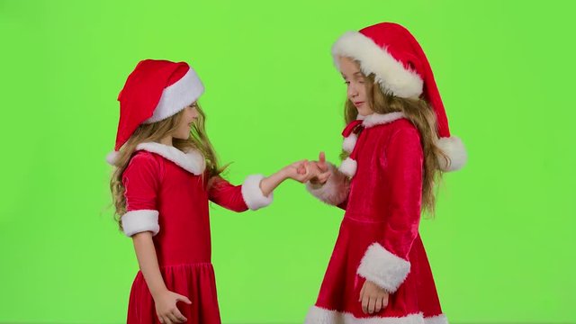 Baby girls in red suits play games, smile and have fun. Green screen