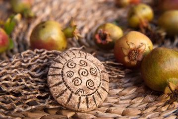 Tribal african brooch with small grenades in pastel tone. Handmade jewelry of polymer clay. Background with jewelry. Artwork still life.
