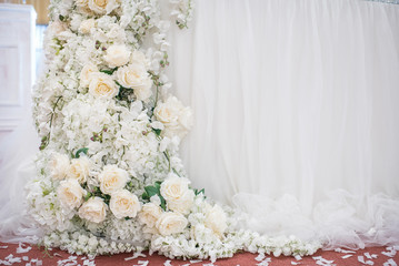 Fashionable decoration of a wedding banquet with white flowers. On the table are crystal vases with floral compositions