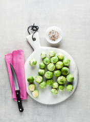 Brussels sprout on a white marble cutting board and knife. spices and food ingredients. cooking healthy food