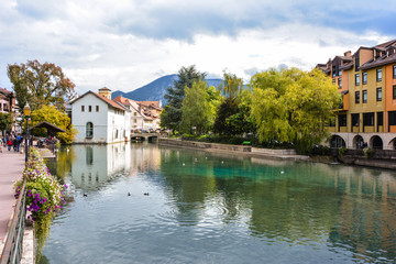 Fototapeta na wymiar City of Annecy. Historical medieval houses and a canal with embroidered flowers and bridges in the resort town of Annecy in France