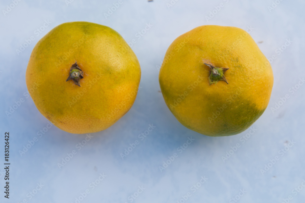 Wall mural two juice oranges isolated on green background. mandarin isolated on green background . top view of 