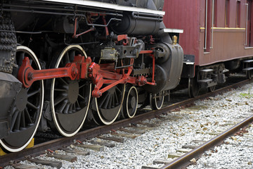 Fototapeta na wymiar Close-up of old steam locomotive wheels, now tourist attraction