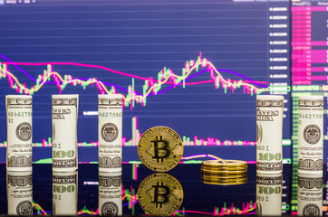 Golden bitcoin and rolled dollar bills on stock market chart background