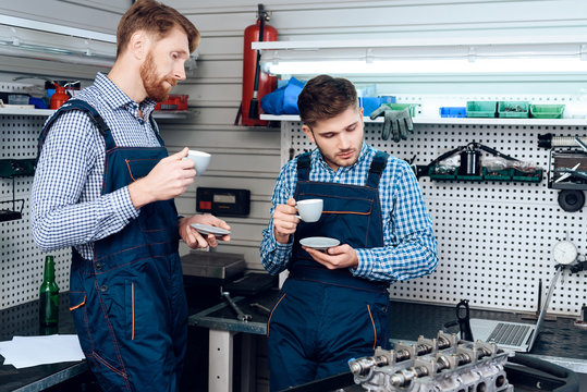 Father and son work at the auto service. Two mechanics work with the details of the car.