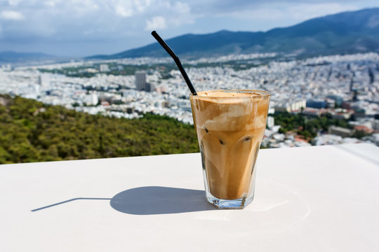 Ice frappe coffee and view of town of Athens for background.
