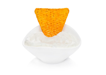 Glass container with sour cream dip and nachos