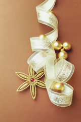 Golden Christmas Ornaments with Satin Ribbon on Brown Background