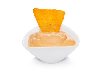 Glass container with cheese dip and nachos chips