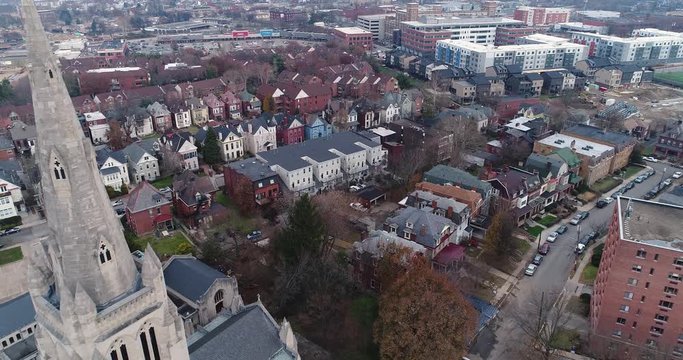 A daytime winter overcast aerial flyover view of a church and houses in Pittsburgh's Shadyside District.  	
