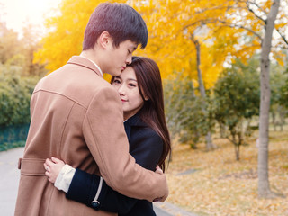 Chinese young man and woman hug  and stand together with emotional expression, lover concept.