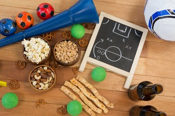 Strategy board, snacks, drink and football on wooden table