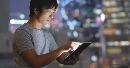 Asian young man use of tablet computer at night