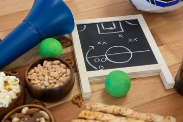 Strategy board, snacks and balls on wooden table