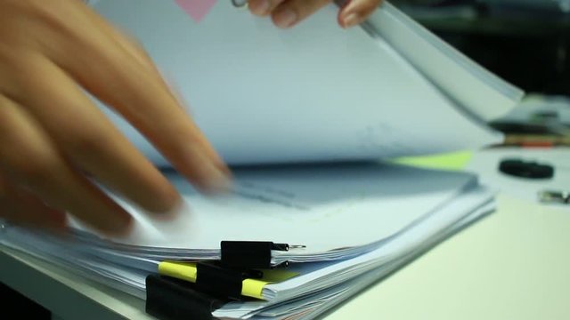 Businesswoman hands working on Stacks of documents files for finance in office. Business report papers or Piles of unfinished document achieves with black clip paper. Concept of Business Annual Report