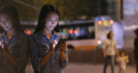 Woman working on mobile phone at night
