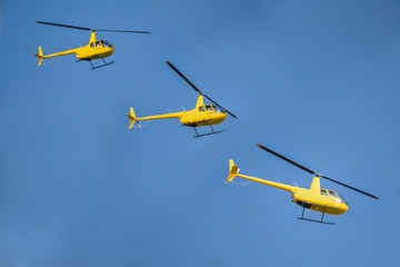 Yellow helicopter auto rotates in the sun