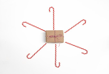 Christmas gift box with candy cane on white background. Top view.