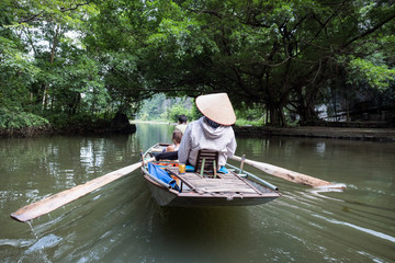 Obraz premium Activity downstream on boat with vietnamese using foot paddle in Ngo Dong river
