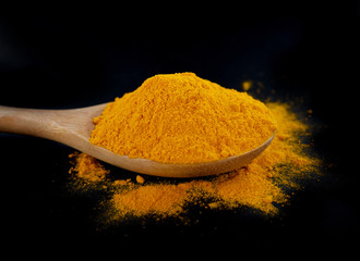 Turmeric powder on black background.