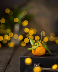 Christmas  tangerine mood!) Fresh tangerines on a wooden vintage background with lights. The best celebration background. Winter xmas holidays concept.
