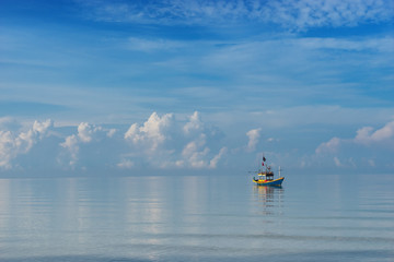 small boat in sea and cloudscape in morning sky