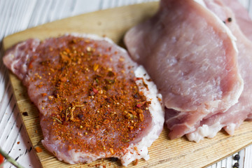 fresh raw meat for steak on wooden cutting board