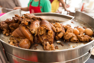 Cooked Stewed pork leg warmed on Aluminium Tray Over Gas Stove ready to Chop and Serve with Rice. It is popular dish local street food in Thailand