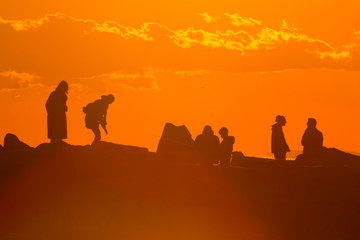 Fototapeta na wymiar Sagome umane al tramonto 