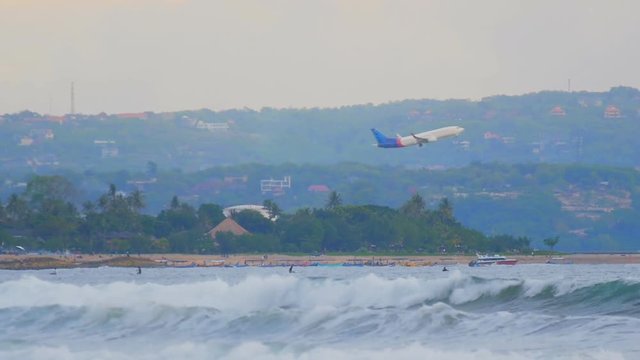 plane takes off over the waves of the ocean at the Bali in slow motion