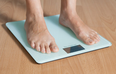 Legs of a young woman on a digital scale. Checking the weight. The concept of weight loss.