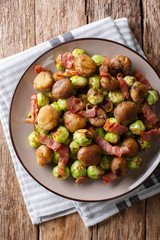 Delicious appetizer: roasted chestnuts, Brussels sprouts and bacon close-up. Vertical top view