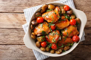 Tuinposter Gerechten Pieces of chicken fried with chestnuts and tomatoes close-up in a bowl. Horizontal top view
