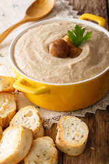 Homemade cream chestnut soup in a saucepan close-up. vertical